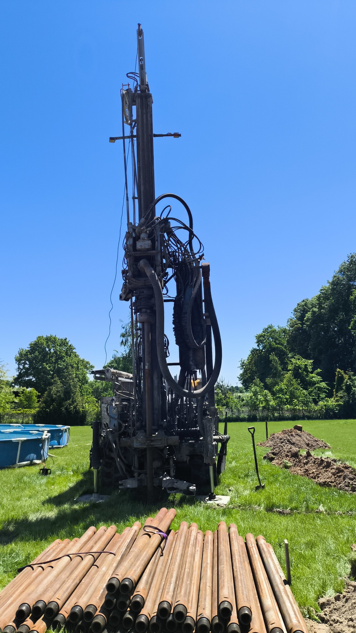 Zbliżenie na profesjonalną głowicę wiertnicy i solidną rurę osłonową używaną do wiercenia studni głębinowych.